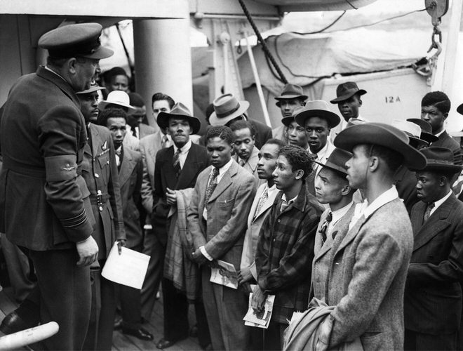 Arrivals on board the ex-troopship, HMT Empire Windrush at Tilbury. An RAF recruiting officer speaks to a group of men interested in joining the Royal Air Force. 22 June 1948